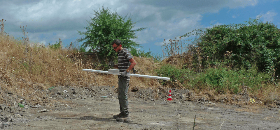 Technician performing electromagnetic survey with field equipment