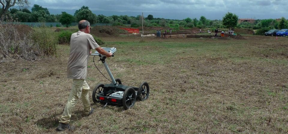 Technicians conducting a geoarchaeological survey using field equipment
